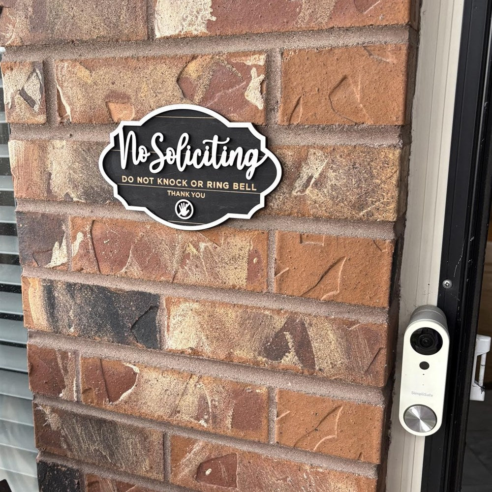 Wooden No Soliciting door sign mounted on a customer's brick wall